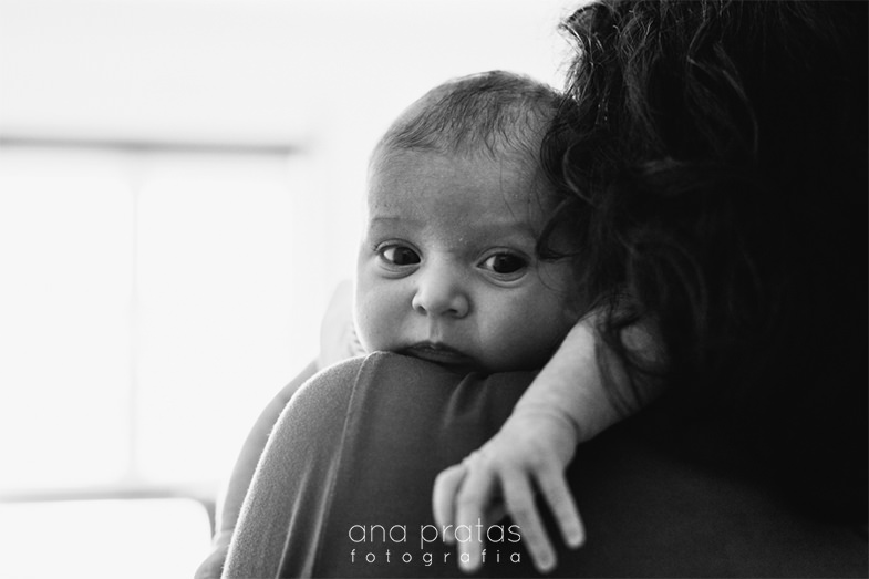 newborn looking through her mother's shoulder