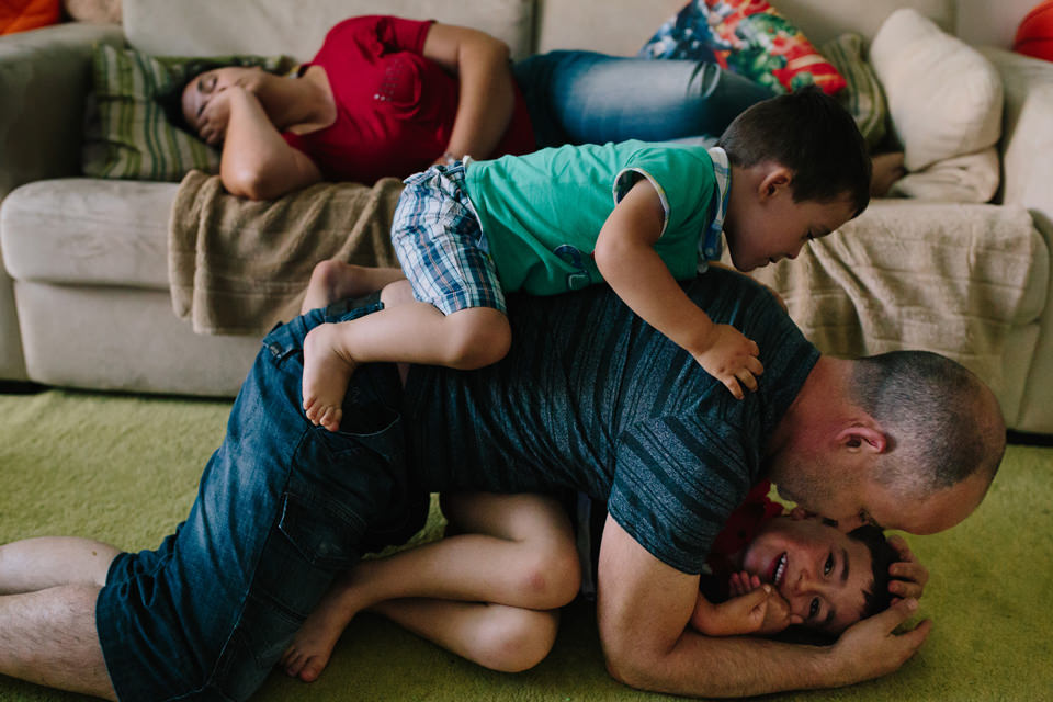 pai brinca com filhos enquanto mae dorme no sofa